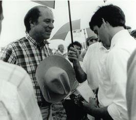 Man talking to reporter under umbrella