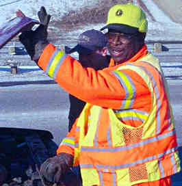 Hwy maintenance worker looking under car hood