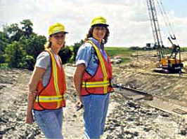 2 women in orange vests outdoors