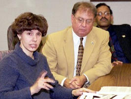 Woman, 2 men at conference table