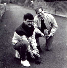 2 men kneeling on bike path