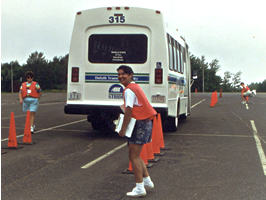 Woman, orange cones & bus on racecourse