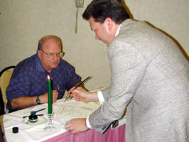 2 men signing papers