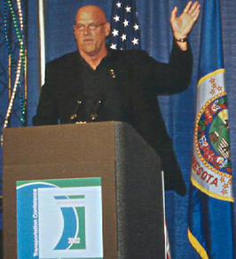 Governor at lectern, waving