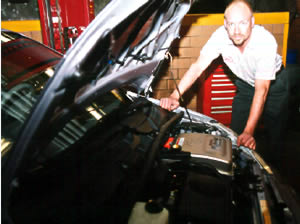 Man under hood of electric car