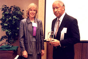 Woman, man holding award