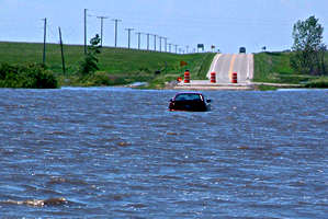 Car on road surrounded by deep water