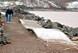 Man walking along damage Lake Superior pathway