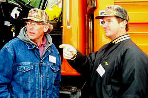 2 men next to orange truck