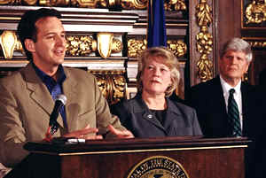 2 men, woman at lectern