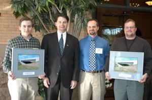 4 men holding awards