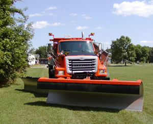 Snowplow on green grass