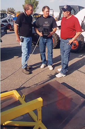 3 men looking at maintenance equipment