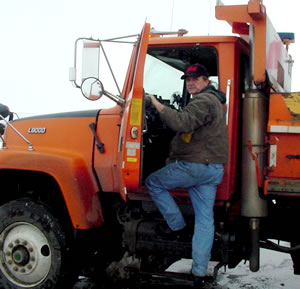 Man climbing into snowplow