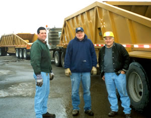 3 men standing near dump truck
