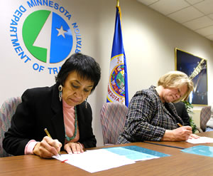 2 women signing tribal agreement