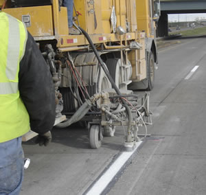 Striping machine applying road stripe