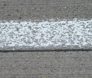 Close-up of white liquid plastic road stripe