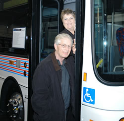 Man, woman standing in bus doorway