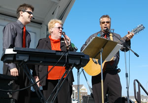 3 people singing on stage