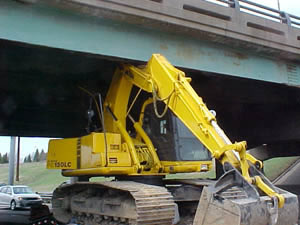 Backhoe stuck under bridge