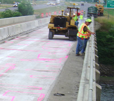 2 construction workers looking over bridge