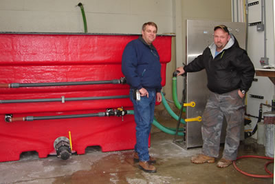 2 men standing next to brine mixer