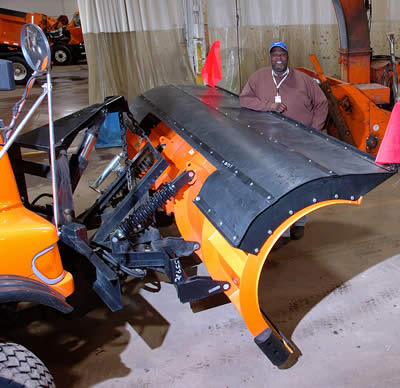 Man standing next to snowplow blade