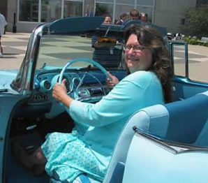 Woman in teal sitting in old teal car