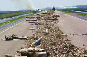 Maintenance crews burn piles of debris left by floodwaters on Hwy 220