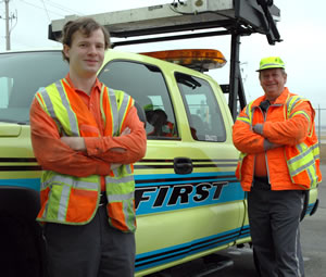 2 men standing next to FIRST truck