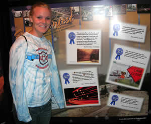 Student stands in front of display