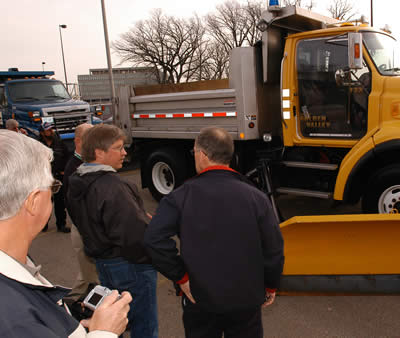 3 men looking at truck with plexiglass door