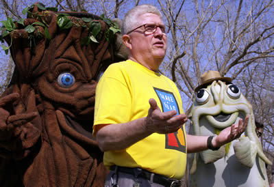 Bob Works standing in front of costumed tree & catfish
