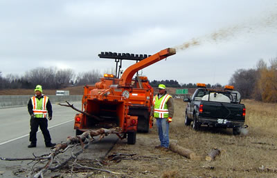 2 men feeding wood chipper