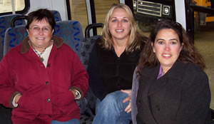 3 women sitting on a bus