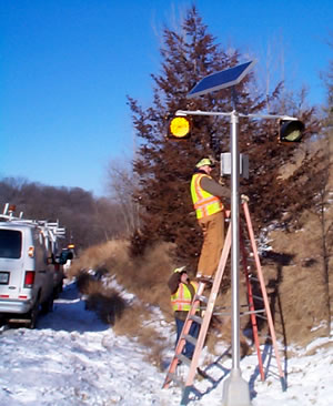 2 men installing warning lights