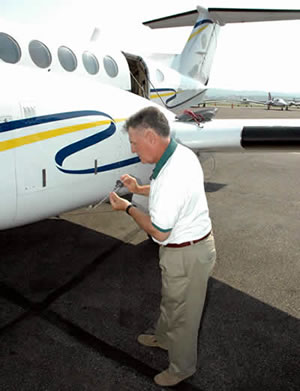 Man checks oil on airplane