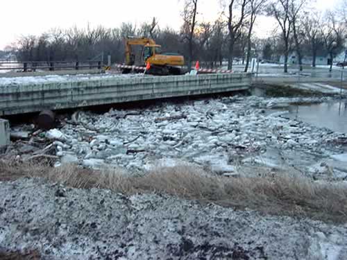 Backhoe on flooded bridge