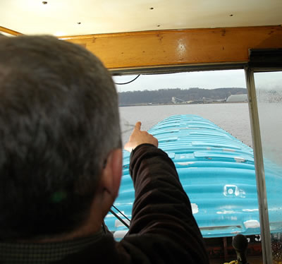 Man in towboat pointing downriver