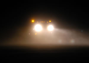 Headlights of oncoming snowplow at night