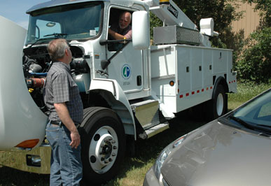 Randy Cameron (at left) and Dave Mitton (in truck), Central Shop supervisors, check out Mn/DOT's first diesel-electric hybid truck shortly after it went into service with the Electric Services Section at Fort Snelling. Photo by Craig Wilkins