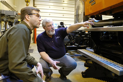 2 men examining truck