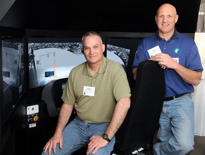 2 men in front of plow simulator