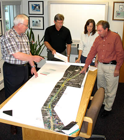 4 people looking at aerial photos