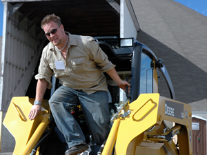 Man hopping out of skid steer