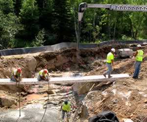 Construction workers pouring bridge footings