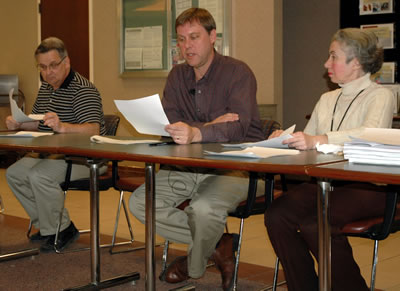 3 people at table reading bids