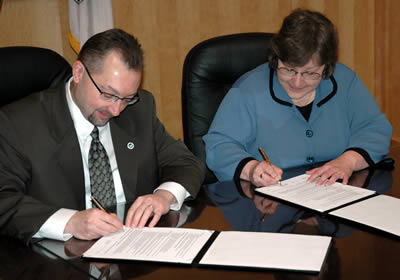 2 people signing MOU