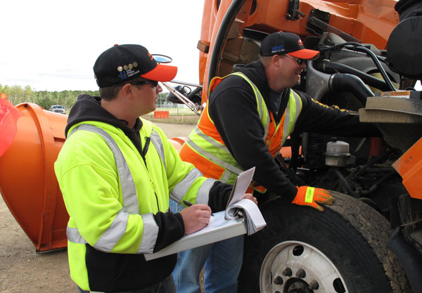 employees inspect truck